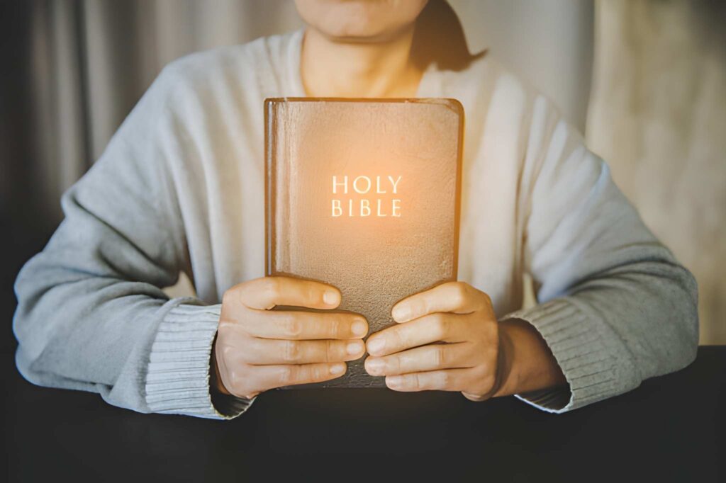 A Christian woman holding a bible in her hands