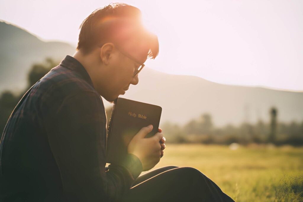 A man sitting with closed eyes with the Bible in his hands