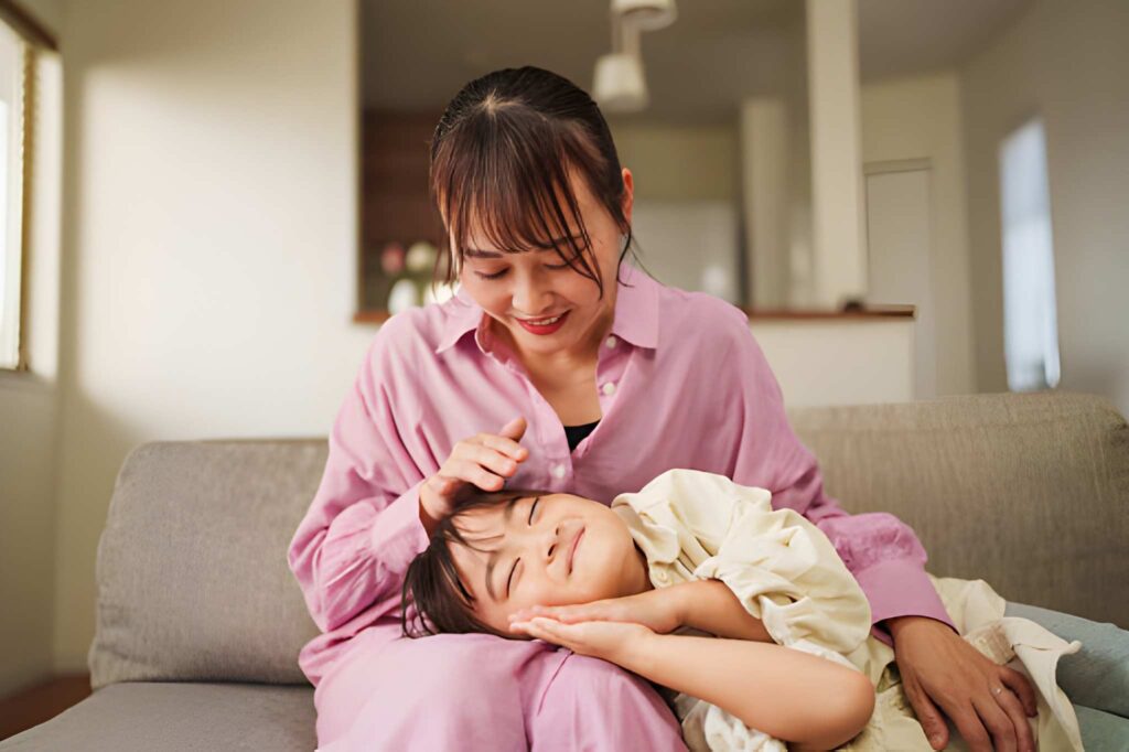 A Mother Stroking Her Daughter’s Hair While She Lies on Her Lap