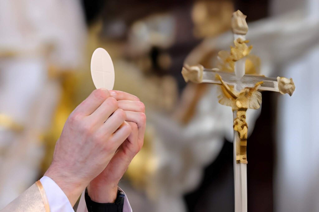Priest celebrate mass at the church lifting communion bread 