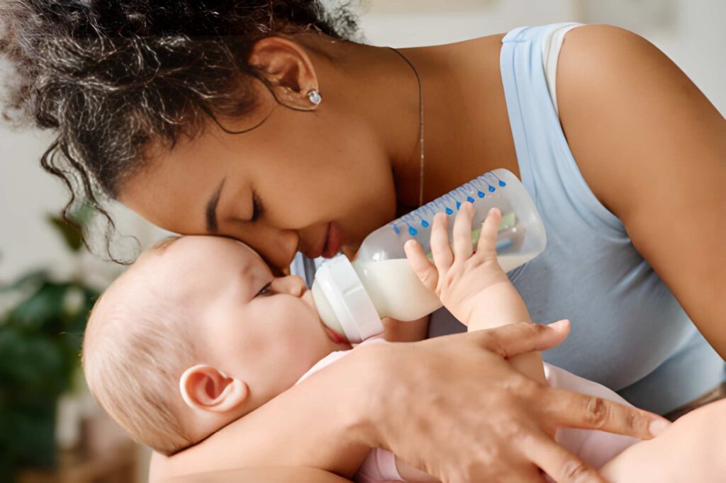 A Happy mother enjoying her time with her baby while he is sucking milk from a bottle