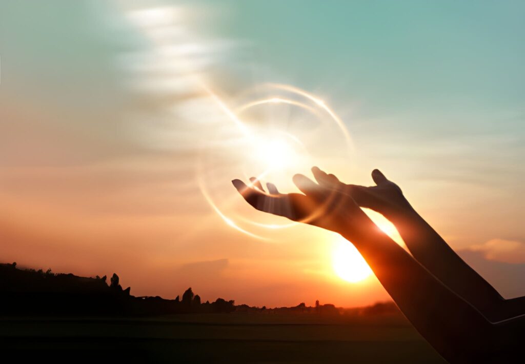 Hands praying for blessing from God on sunset background