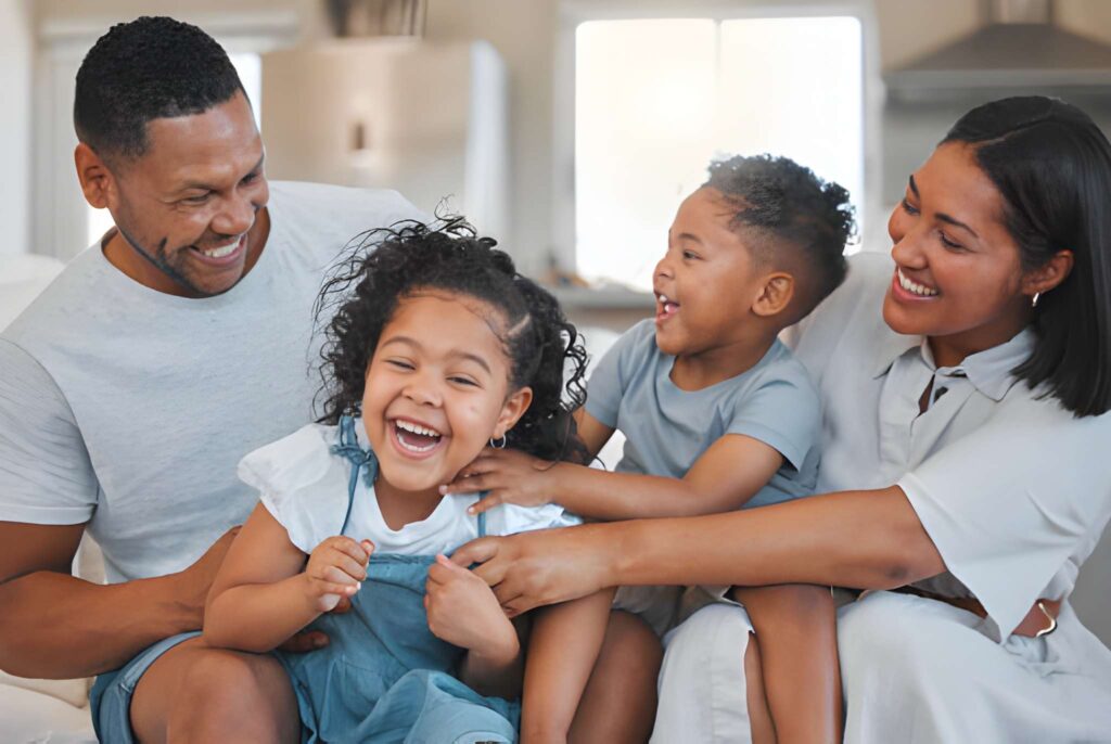 A young family happily bonding together on the sofa at home 